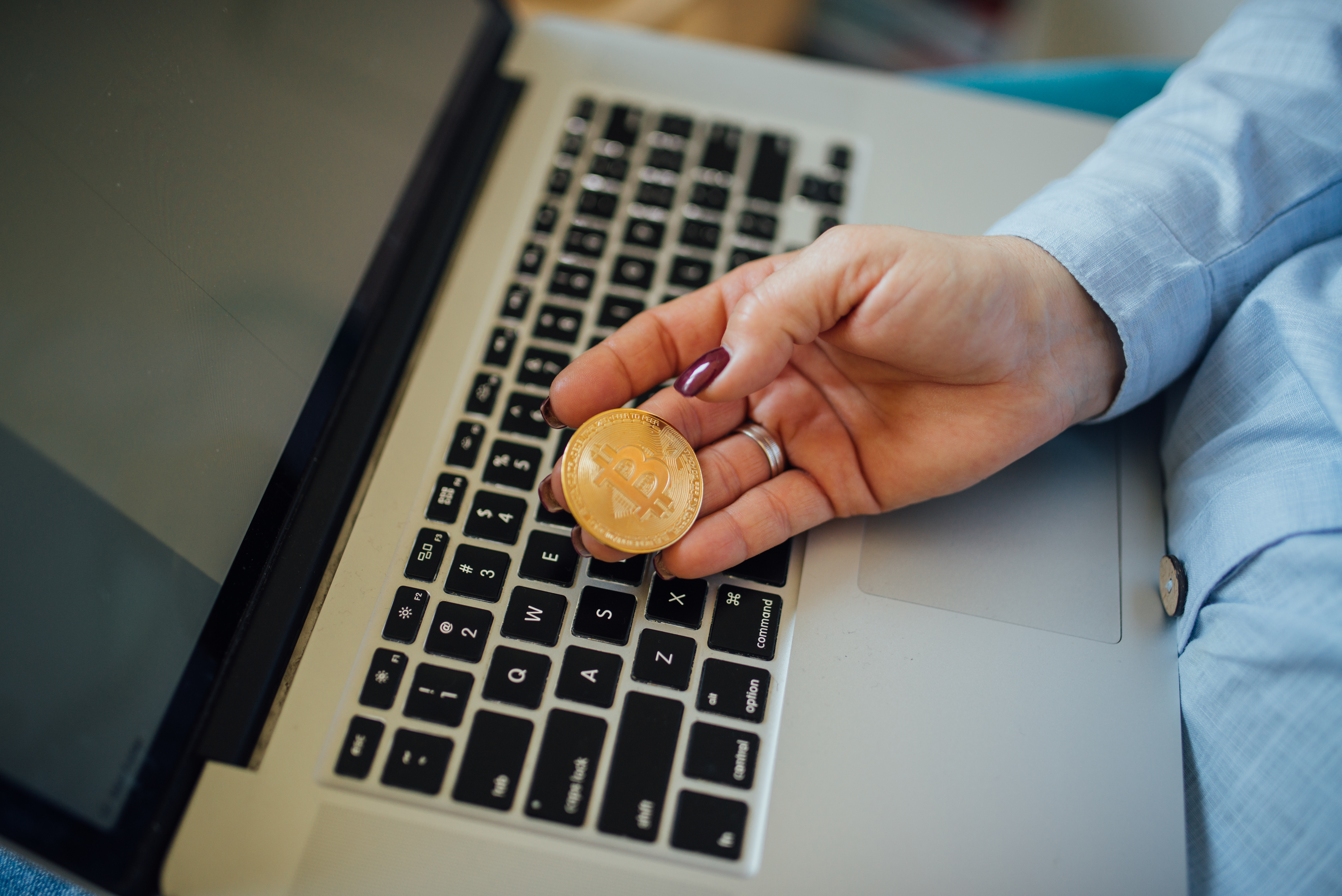 Đồng Bitcoin vật lý đặt cạnh máy tính.